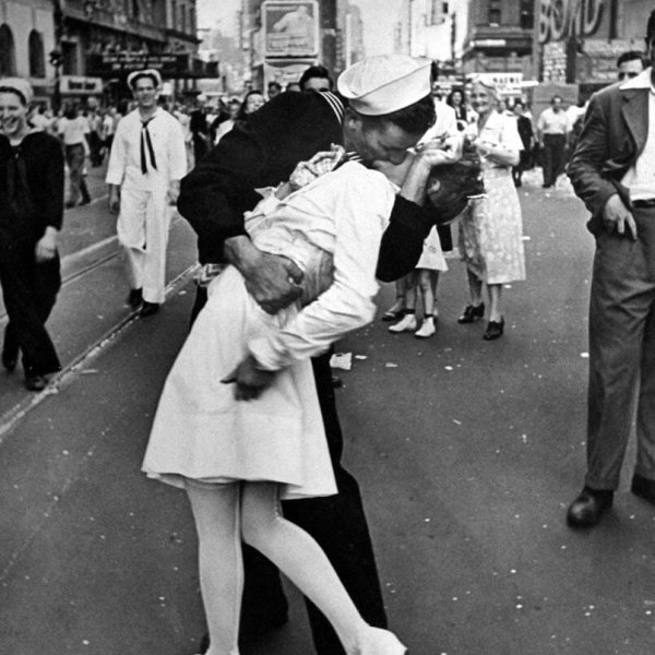 Caption from the August 27, 1945, issue of LIFE. "In the middle of New York's Times Square a white-clad girl clutches her purse and skirt as an uninhibited sailor plants his lips squarely on hers."